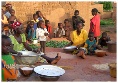 image représentant 2 femmes en train de préparer le repas. Elles sont entourées d'enfants.
